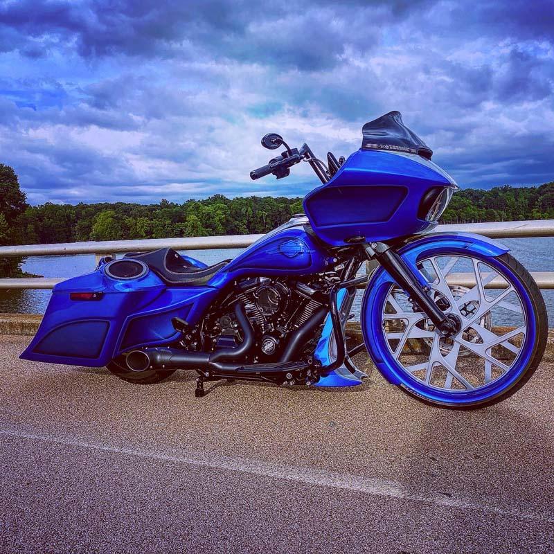 A blue motorcycle parked on the side of a road, ready to hit the open highway.