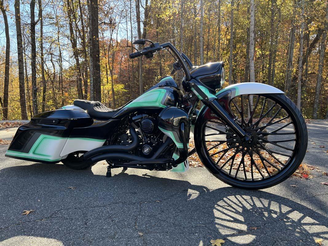 A black and green motorcycle parked on the road, ready to hit the streets with its sleek design and powerful engine.