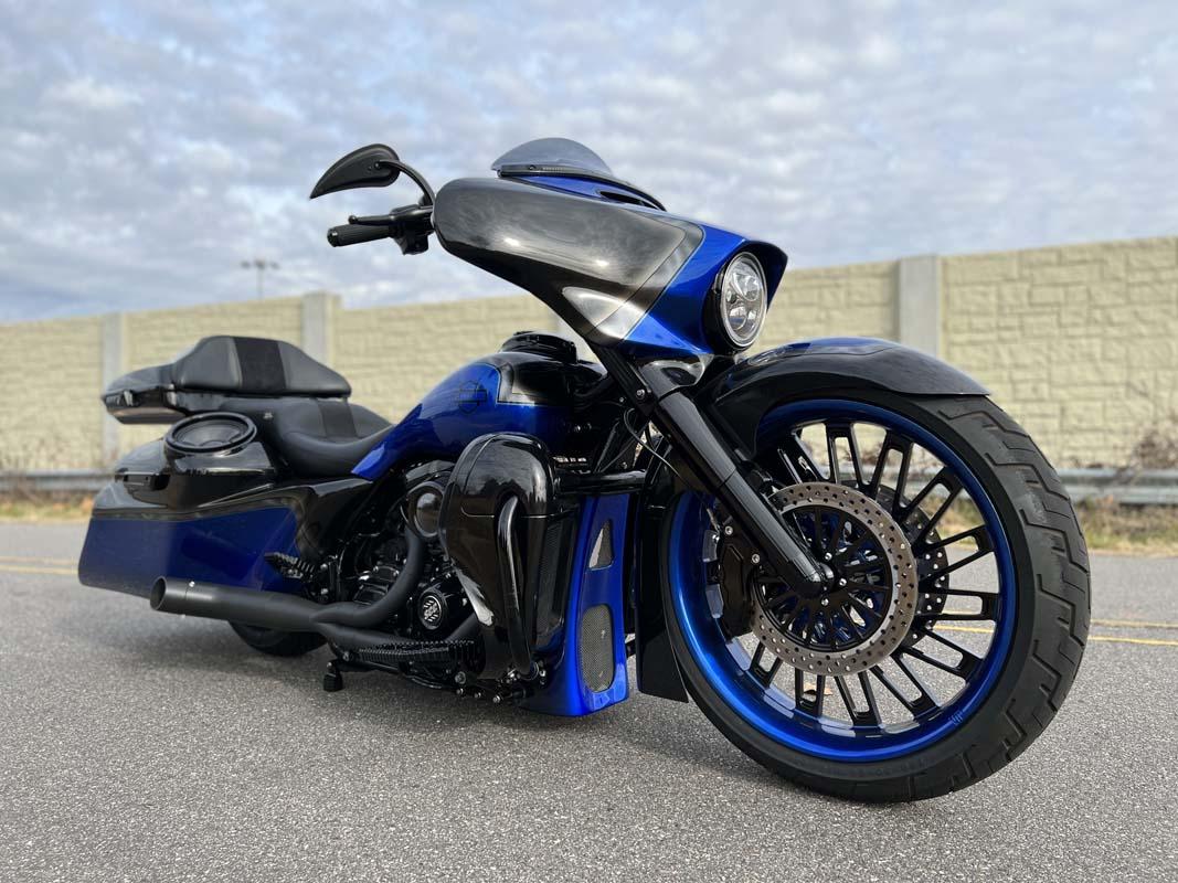 A parked blue and black motorcycle on the side of the road.