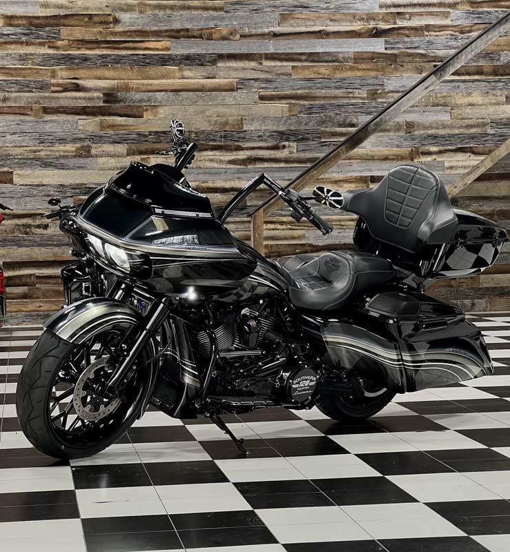 A black motorcycle parked in a room with a checkered floor.