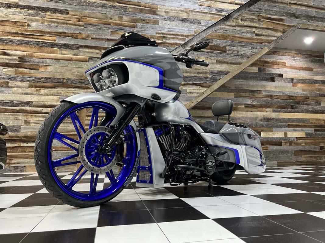 Blue-rimmed motorcycle with white tires, adding a pop of color to the showroom.
