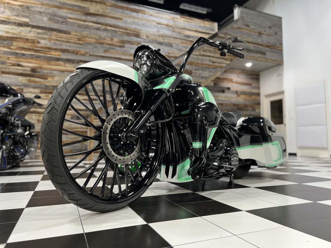 Green motorcycle parked on checkered floor.