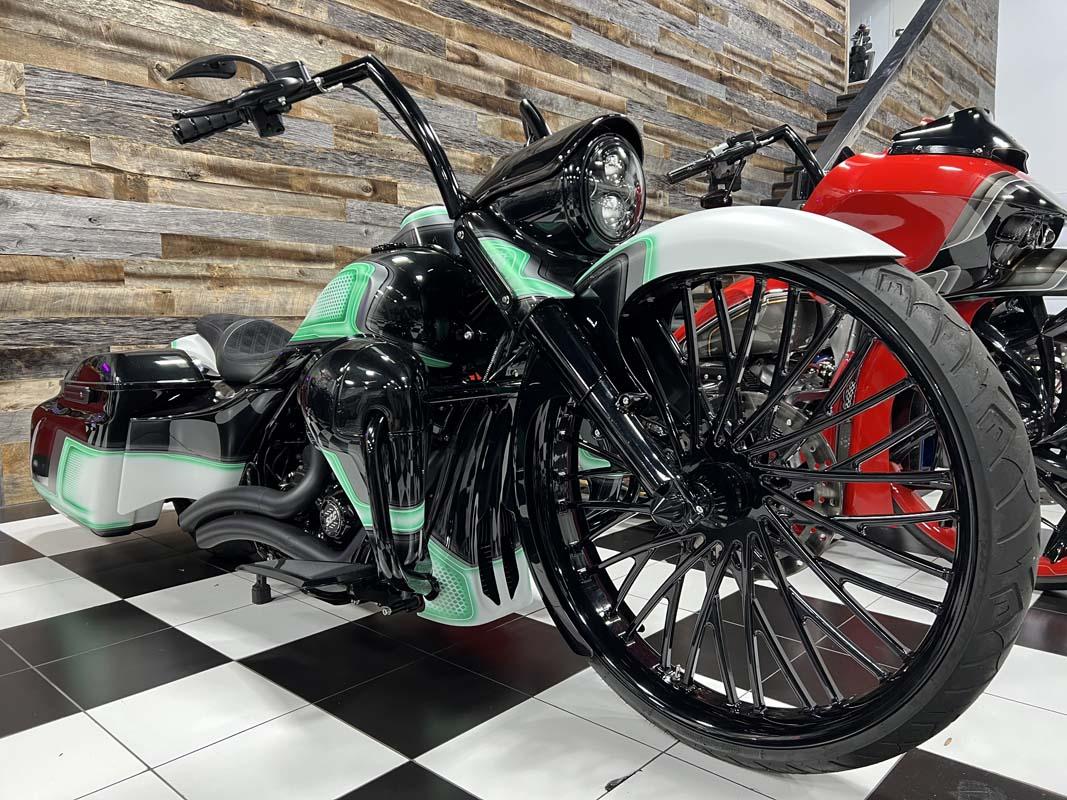 Green and black motorcycle parked on checkered floor.