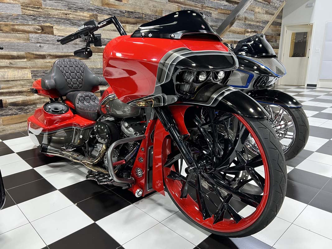 A red motorcycle parked in a showroom, showcasing its sleek design and vibrant color.