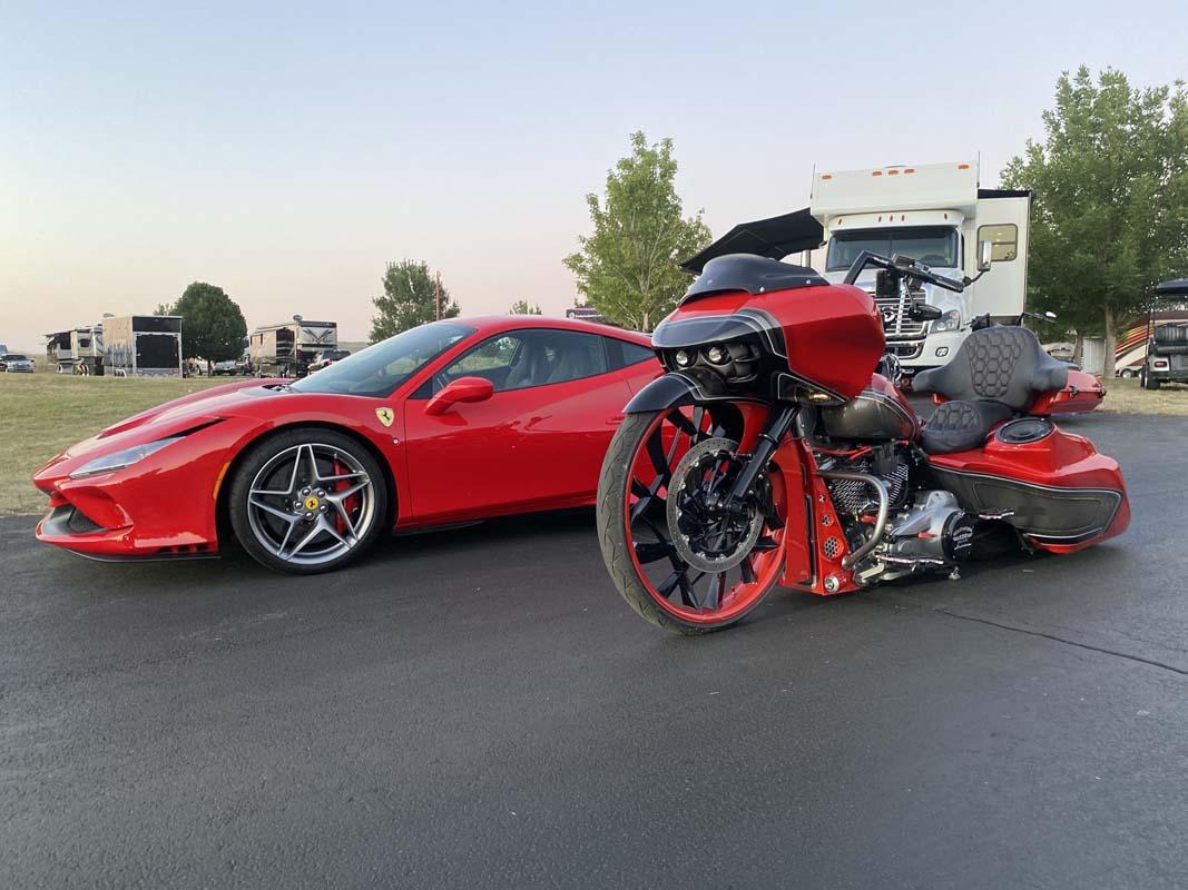 A red sports car and a motorcycle parked side by side, showcasing their sleek design and vibrant colors.